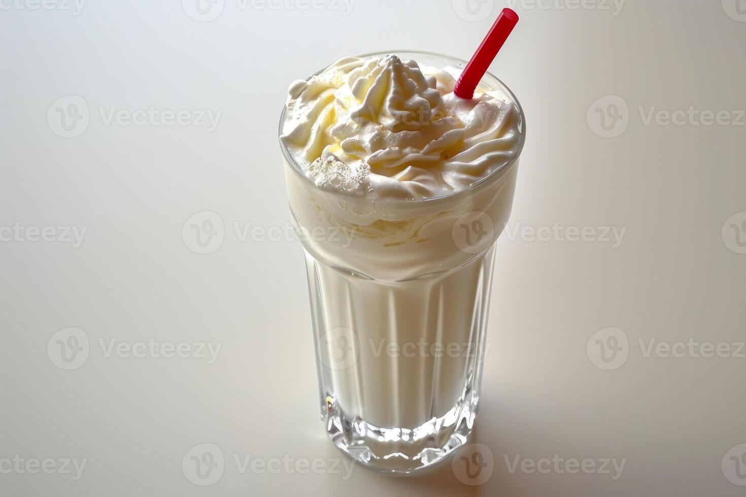 Vanilla milkshake with whipped cream and red straw on white background photo