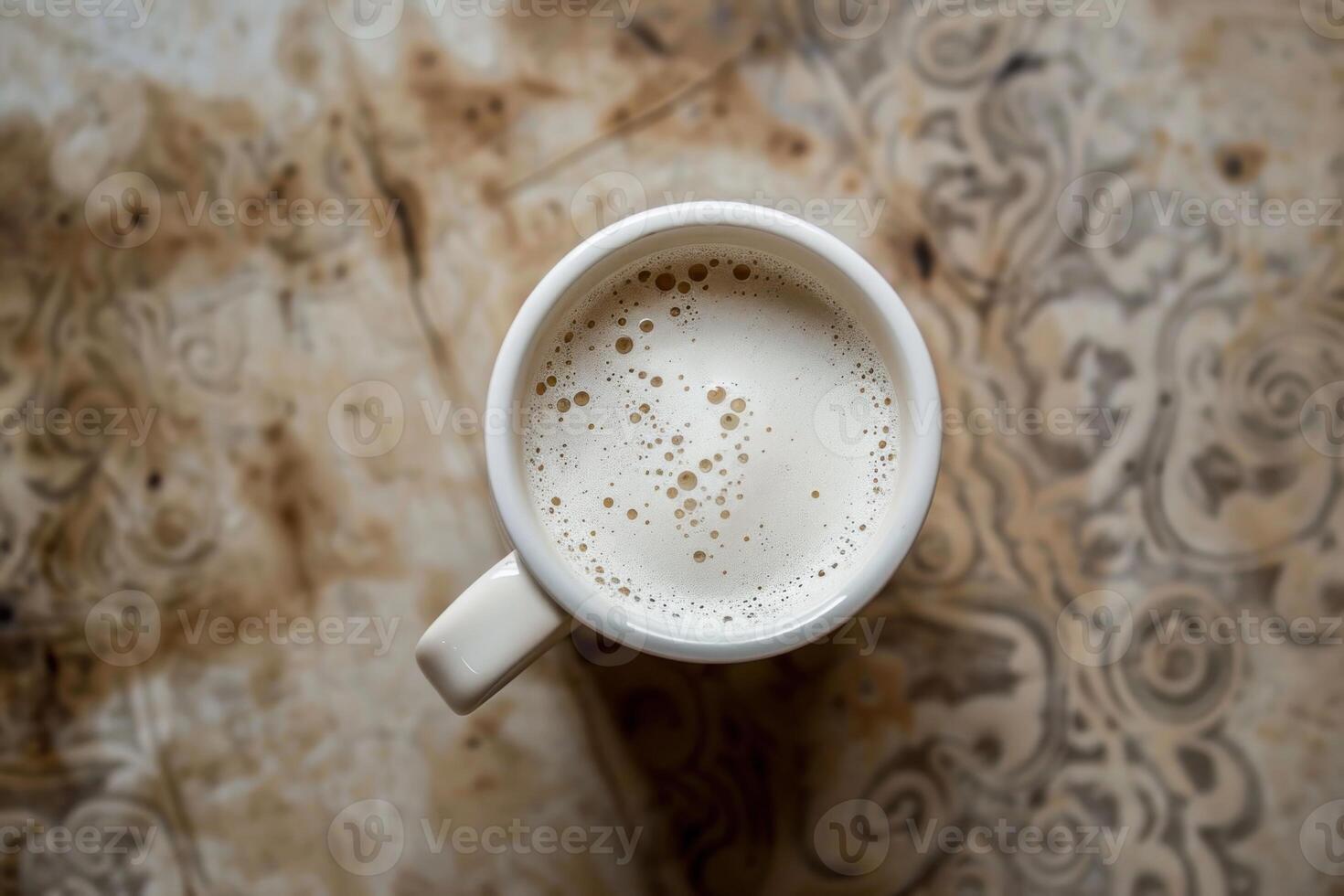 Coffee cup resting on distressed wooden table with stains photo