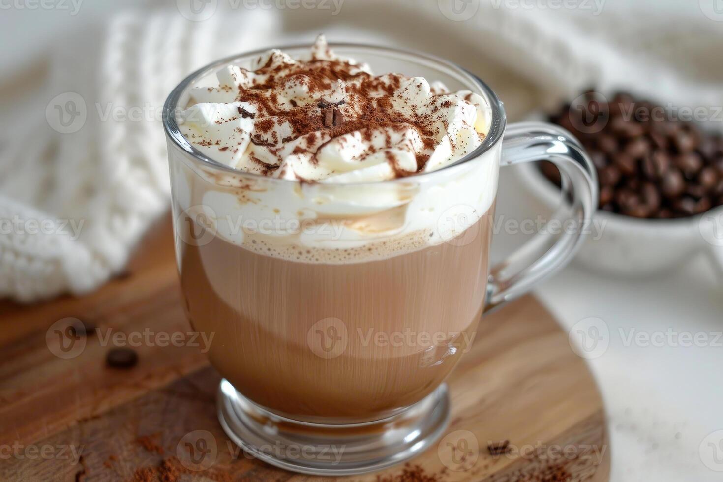 Glass cup of hot coffee with whipped cream and coffee beans on cozy wooden board photo