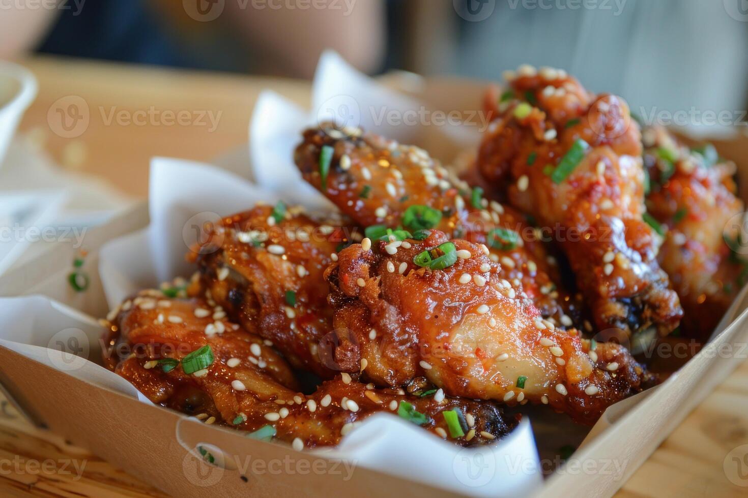 A box of chicken wings with sesame seeds on top photo