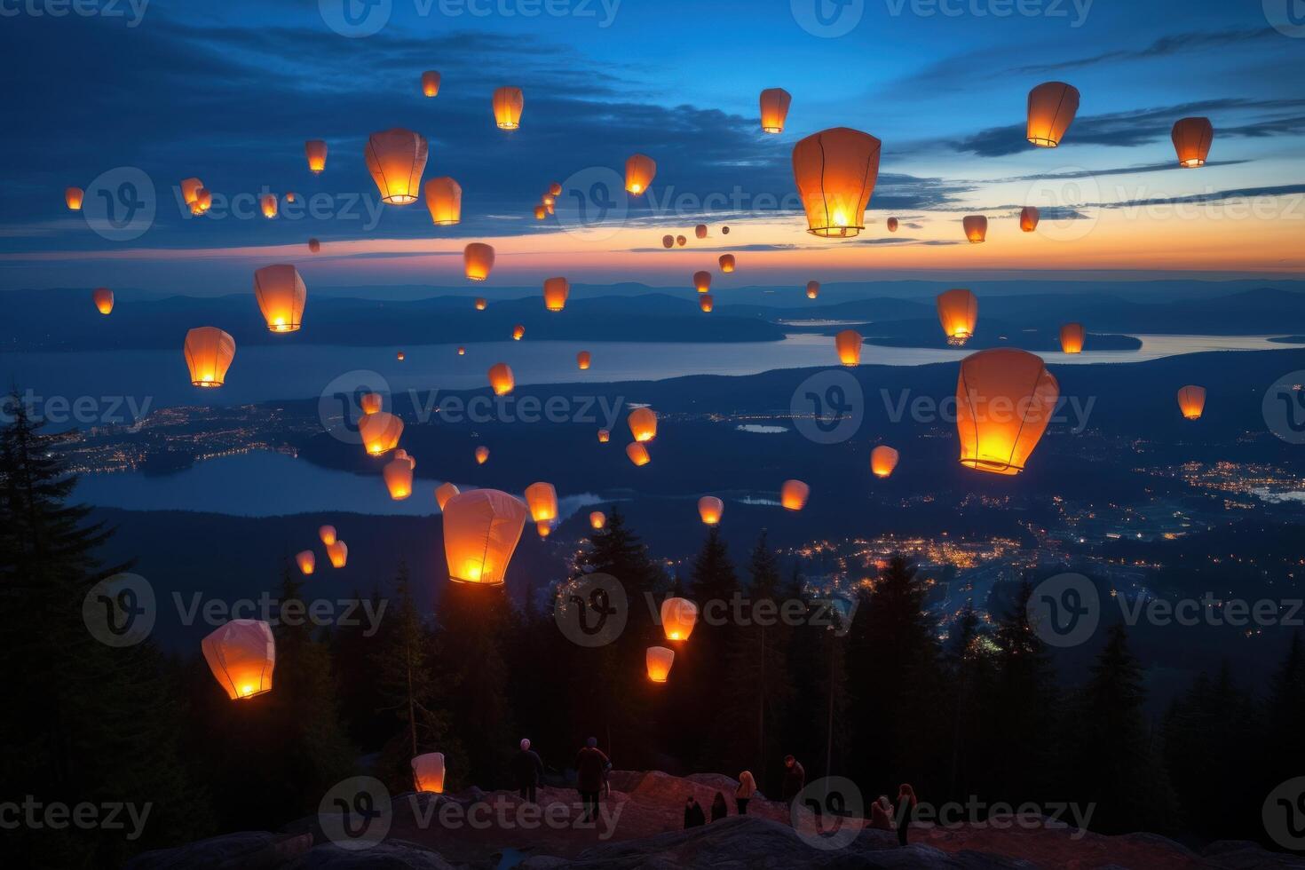 Sky lanterns illuminating the night over a scenic mountain landscape photo