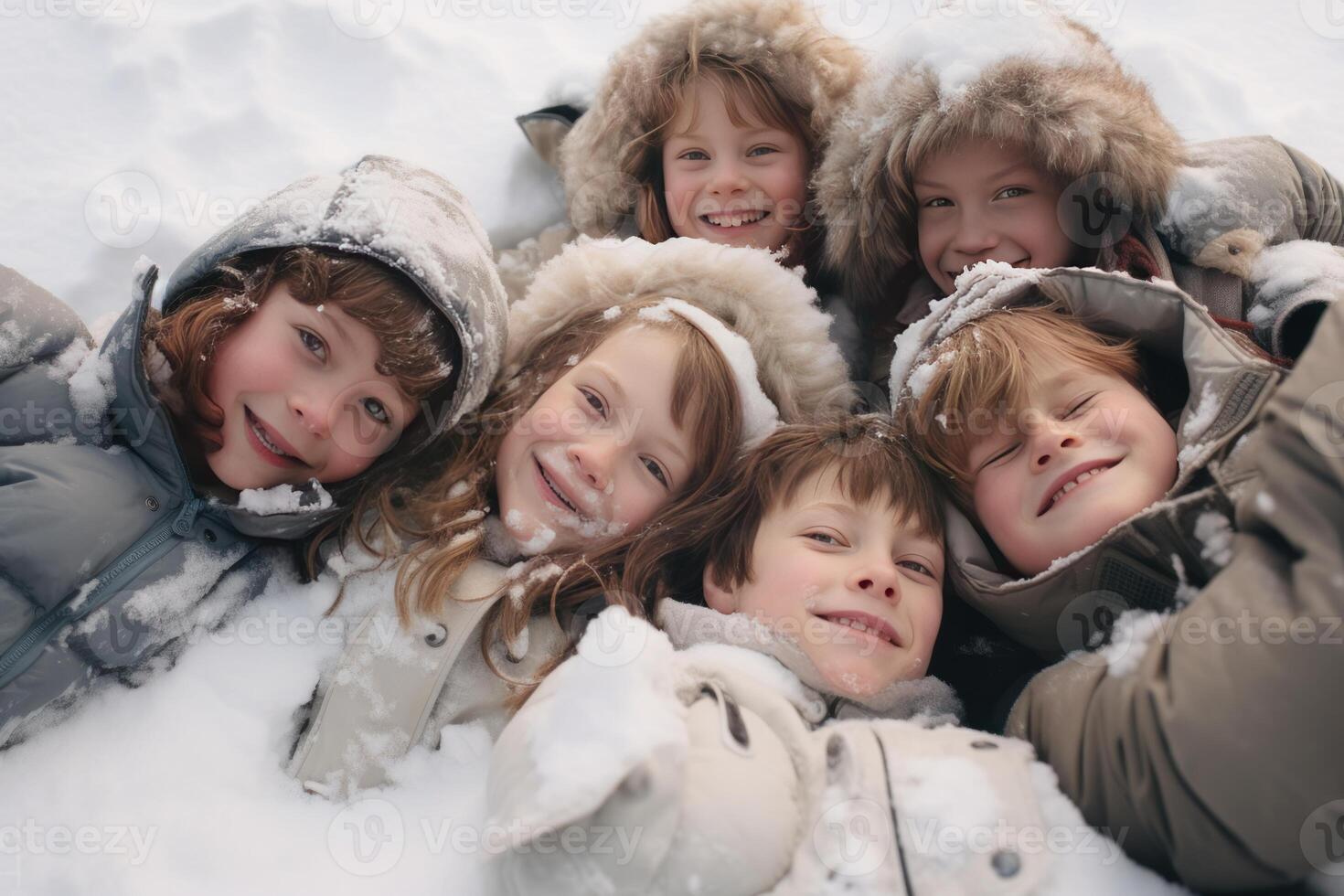 Happy children lying in the snow enjoying winter holidays photo