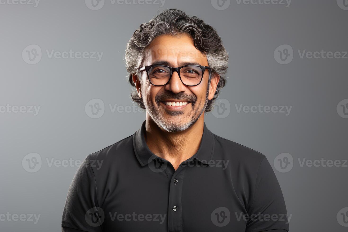 Smiling middle aged man with glasses and gray hair posing on gray background photo