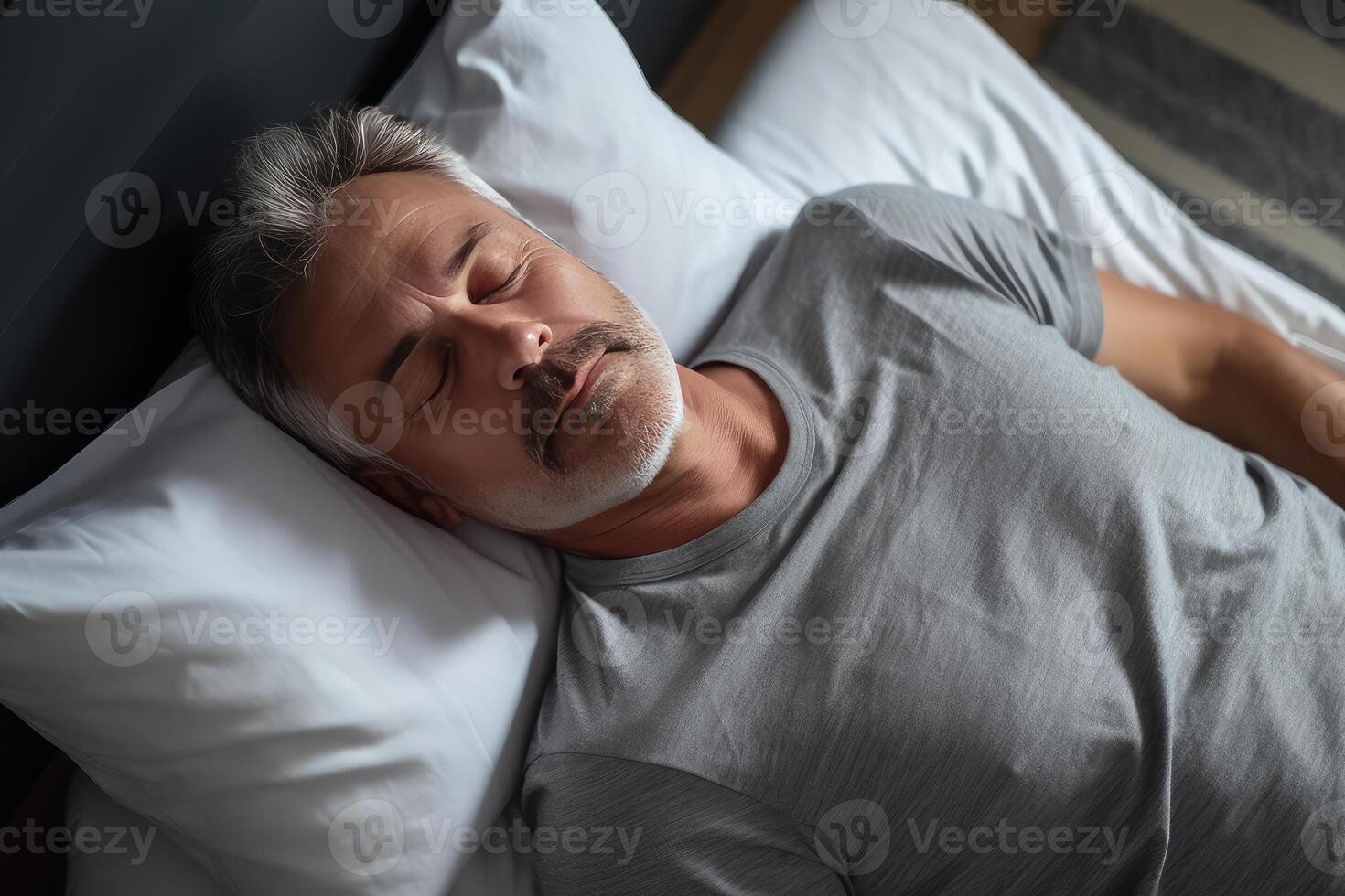Senior man sleeping peacefully in bed, rest and relaxation photo