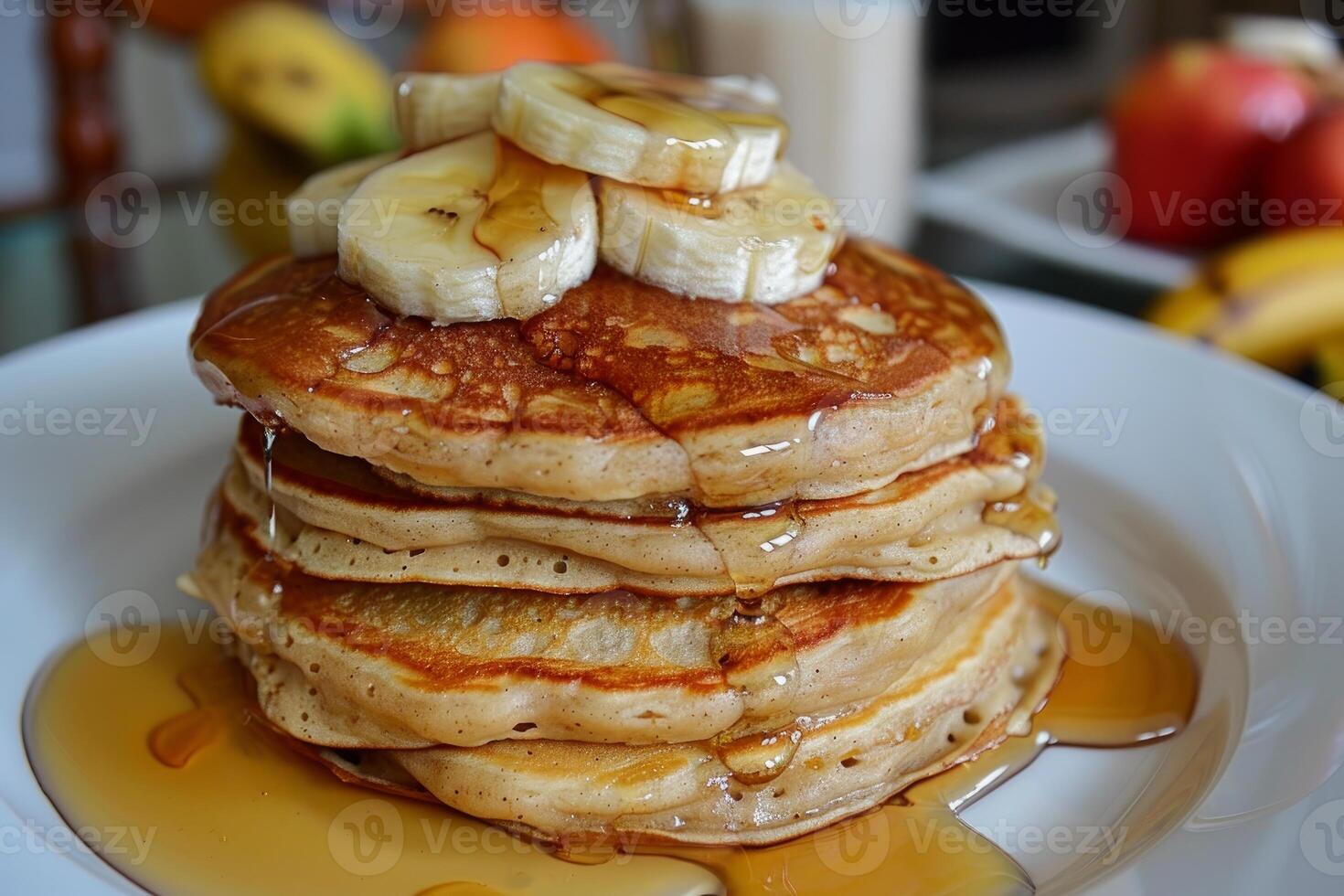 Stack of pancakes with sliced banana and syrup drizzled on top photo