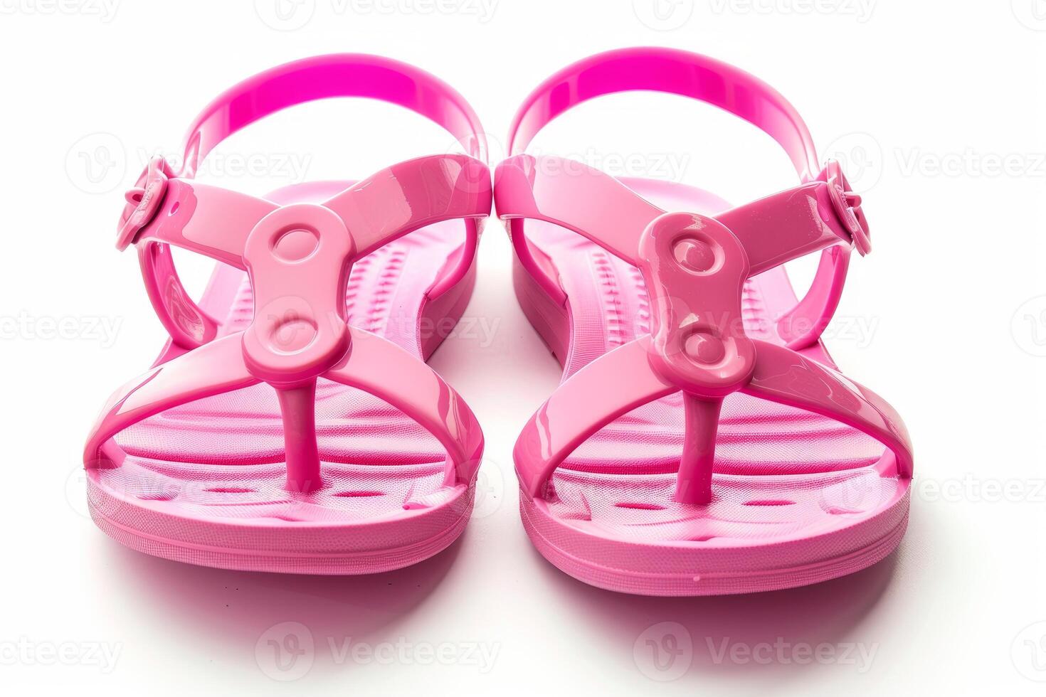 Pair of pink girl's sandals resting on white background photo