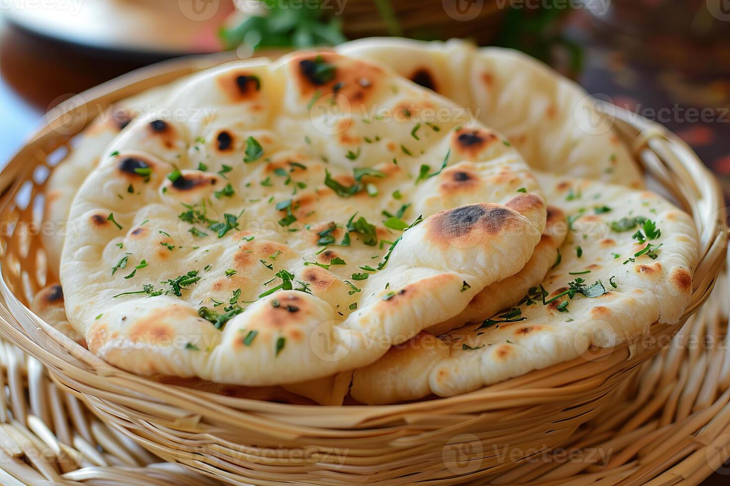 Freshly baked naan bread garnished with parsley in a basket photo