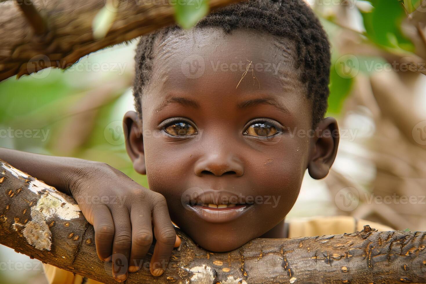 Portrait of smiling african child leaning on branch photo