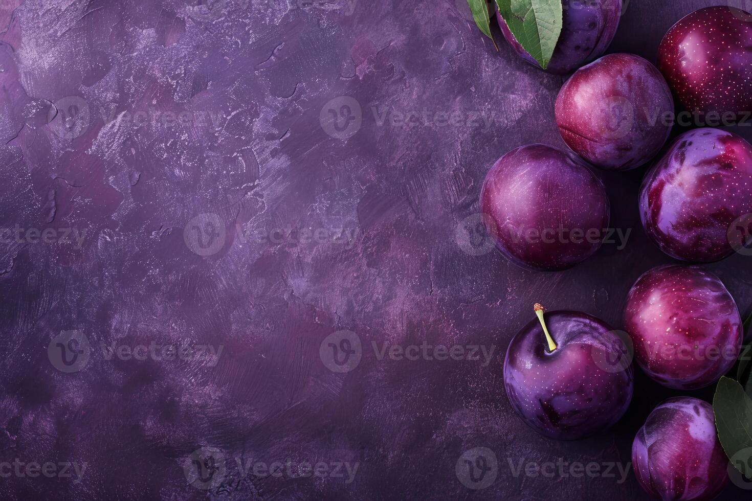 Fresh purple plums with green leaves on dark background creating vibrant contrast photo