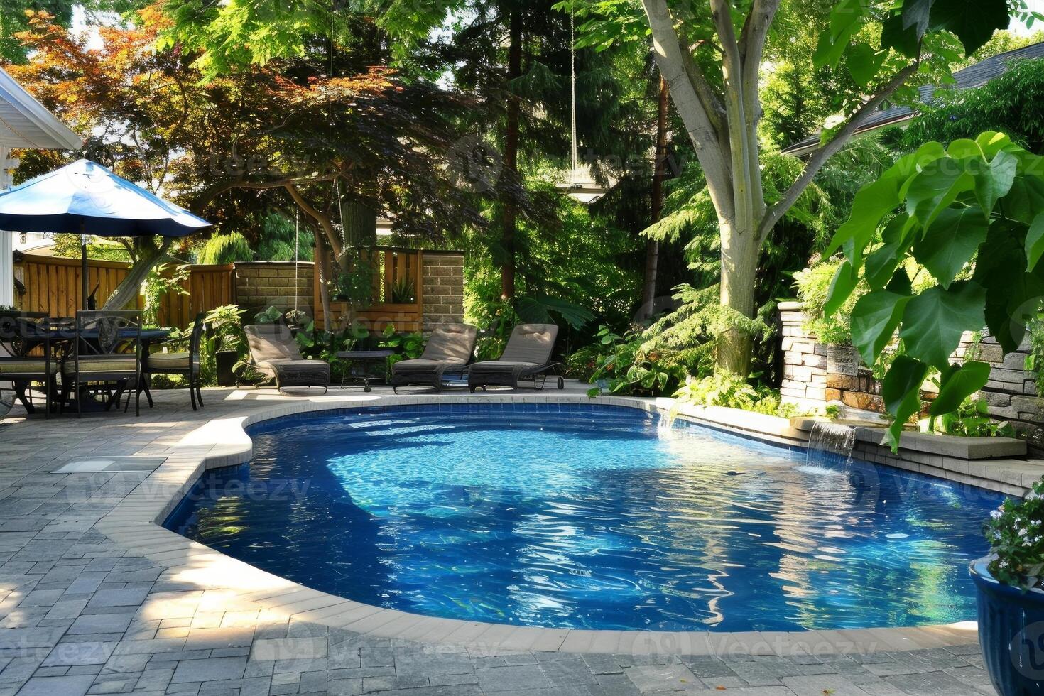Backyard inground swimming pool with waterfall cascading into crystal clear water on sunny summer day photo