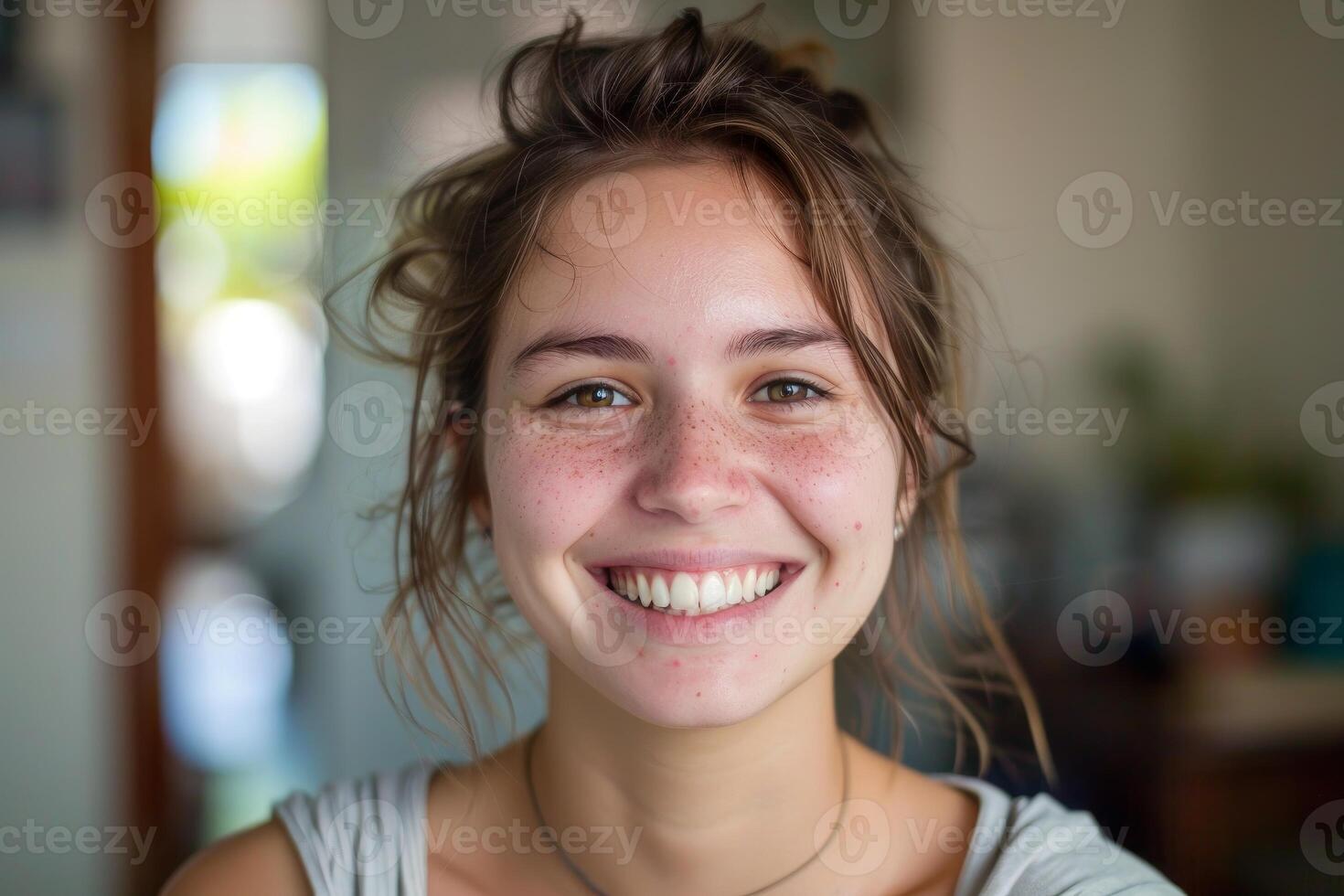 Portrait of smiling young woman with freckles showing happiness and confidence photo