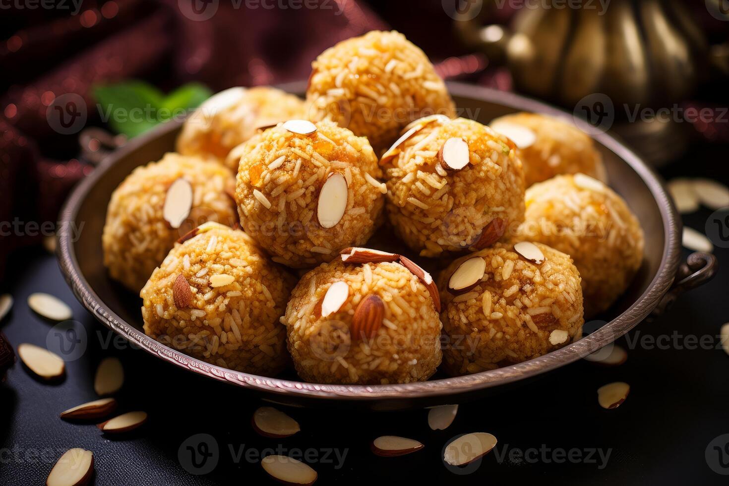 Delicious motichoor ladoo garnished with almond flakes resting on metal plate photo