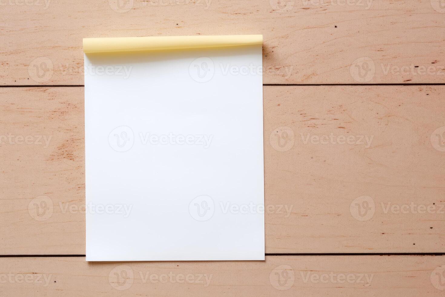 Blank white paper with yellow sticky tape on wooden table photo
