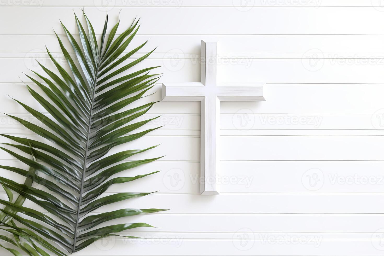 White christian cross and palm branch hanging on white wooden wall for palm sunday photo