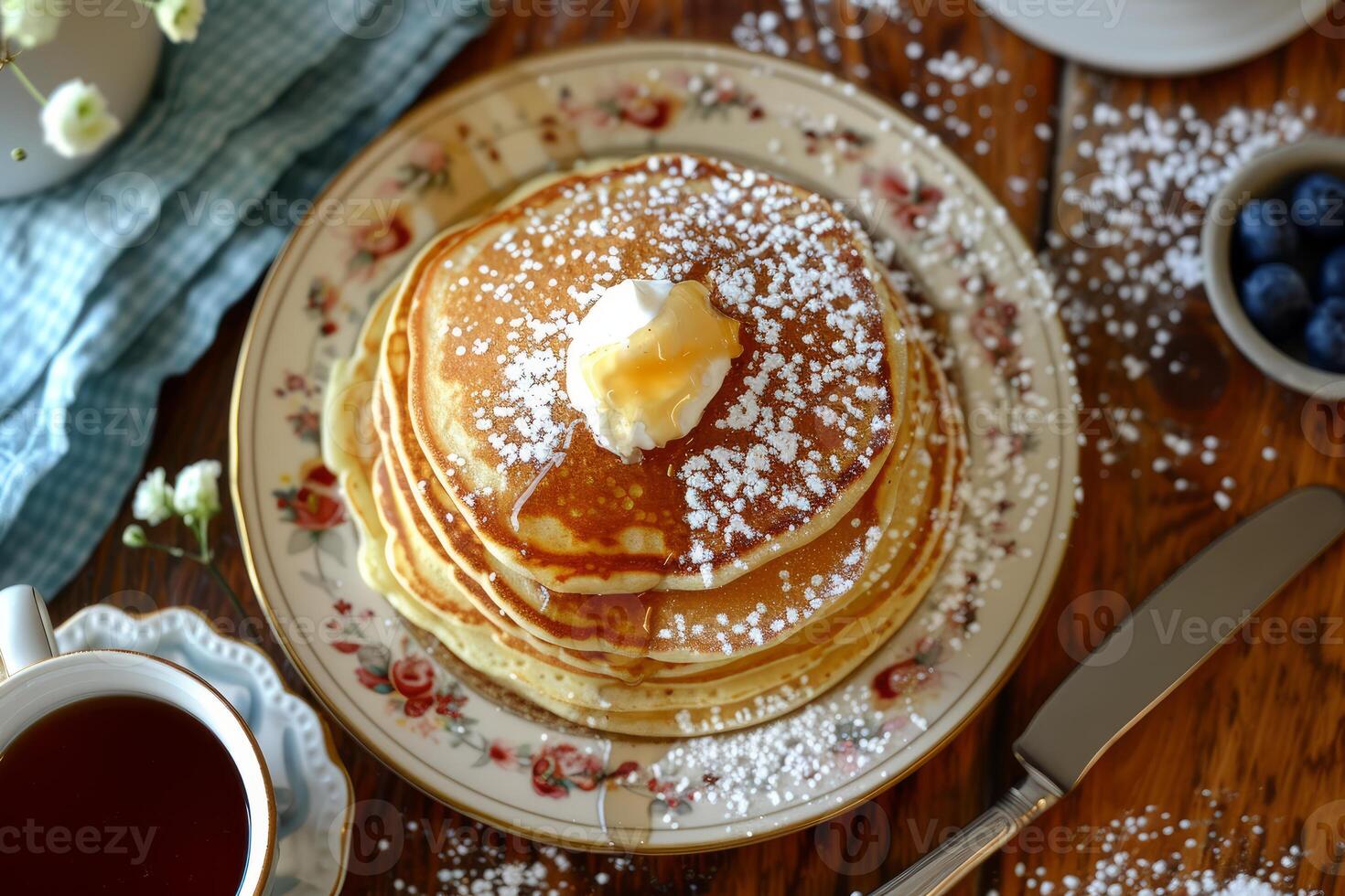 Stack of pancakes with syrup, whipped cream, and powdered sugar for breakfast photo