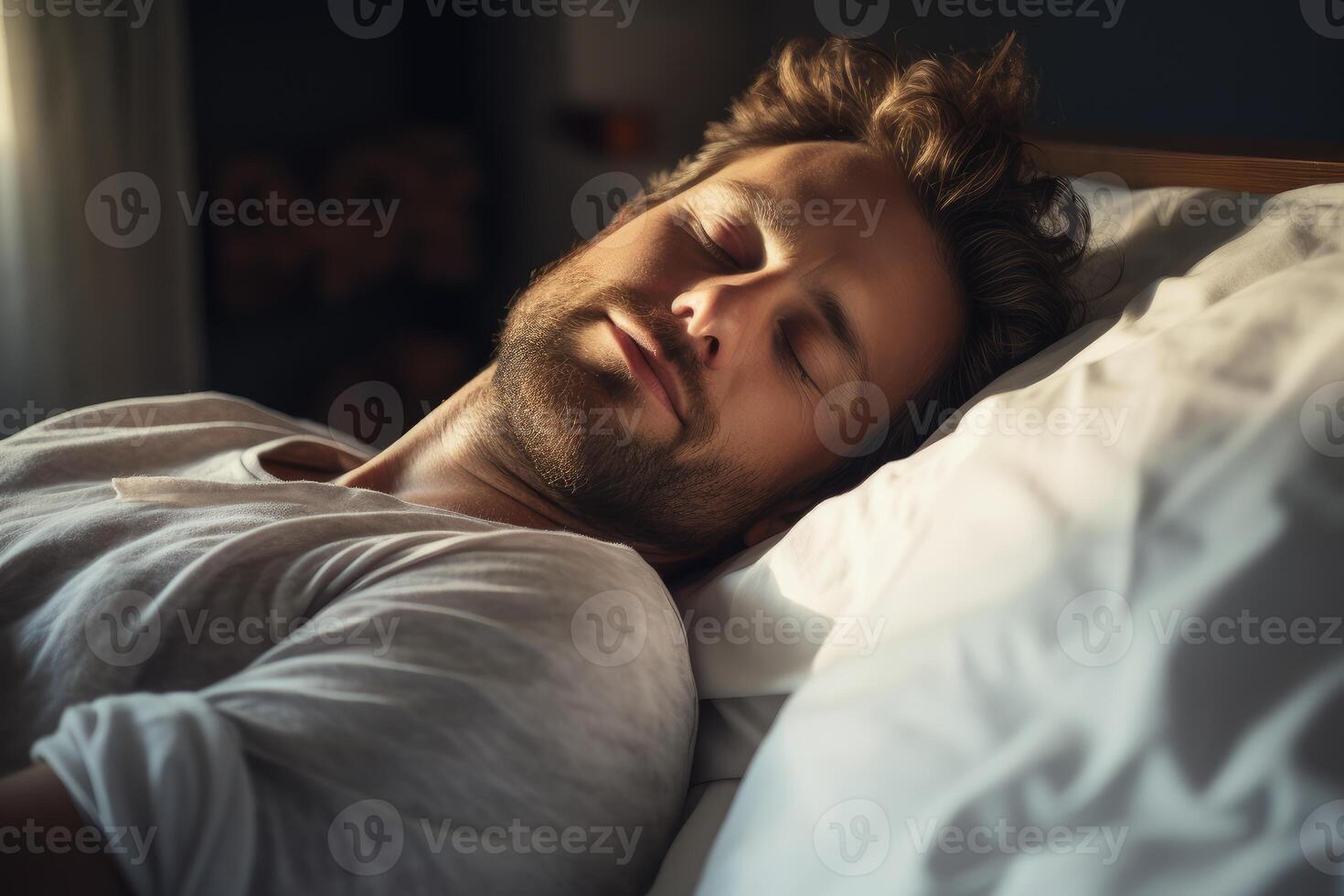 Handsome man sleeping peacefully in bed, enjoying restful sleep in morning light photo