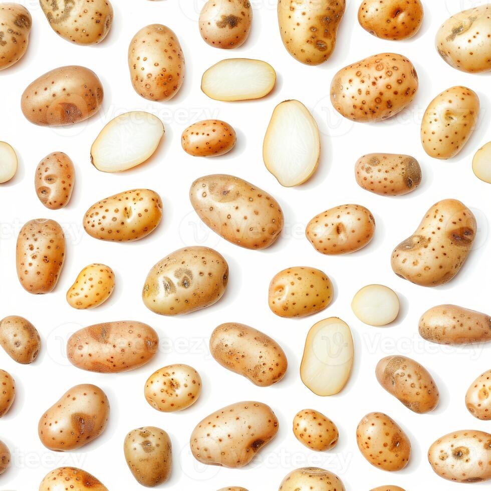 Pattern of whole and halved potatoes lying on white background photo