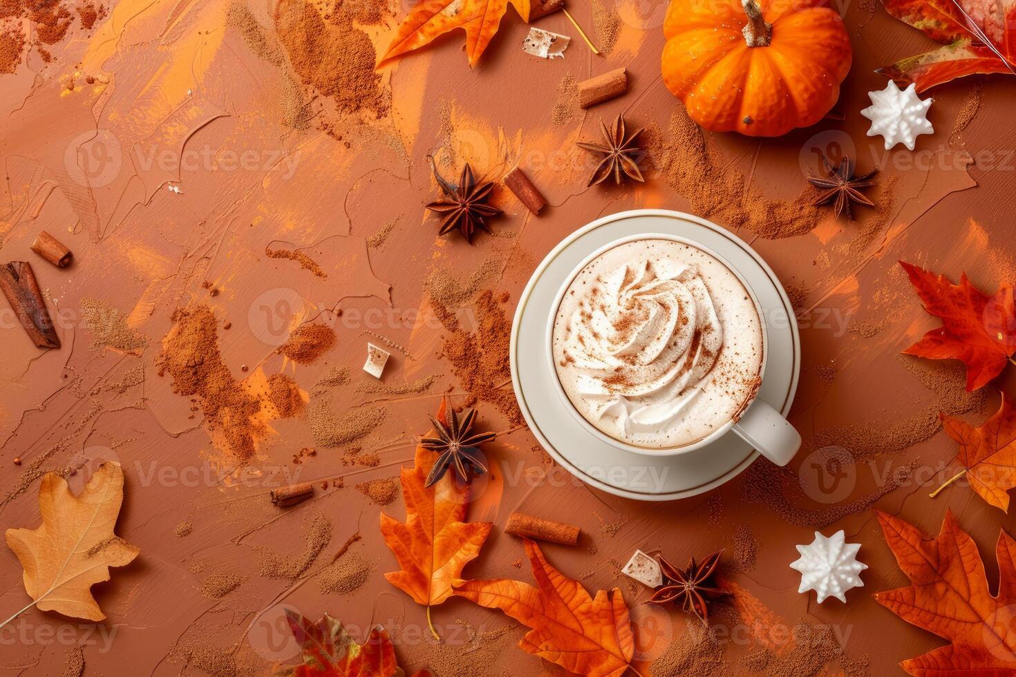 Pumpkin spice latte surrounded by autumn decoration with cinnamon and maple leaves photo
