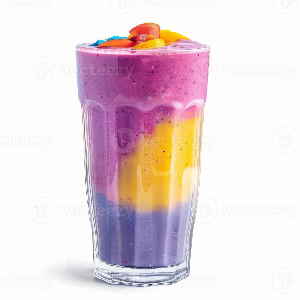 Colorful layered smoothie garnished with candies and fruit slices in a tall glass photo