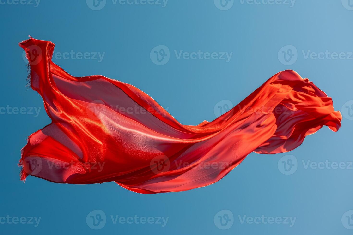 Red fabric flowing gracefully in the wind against blue sky photo