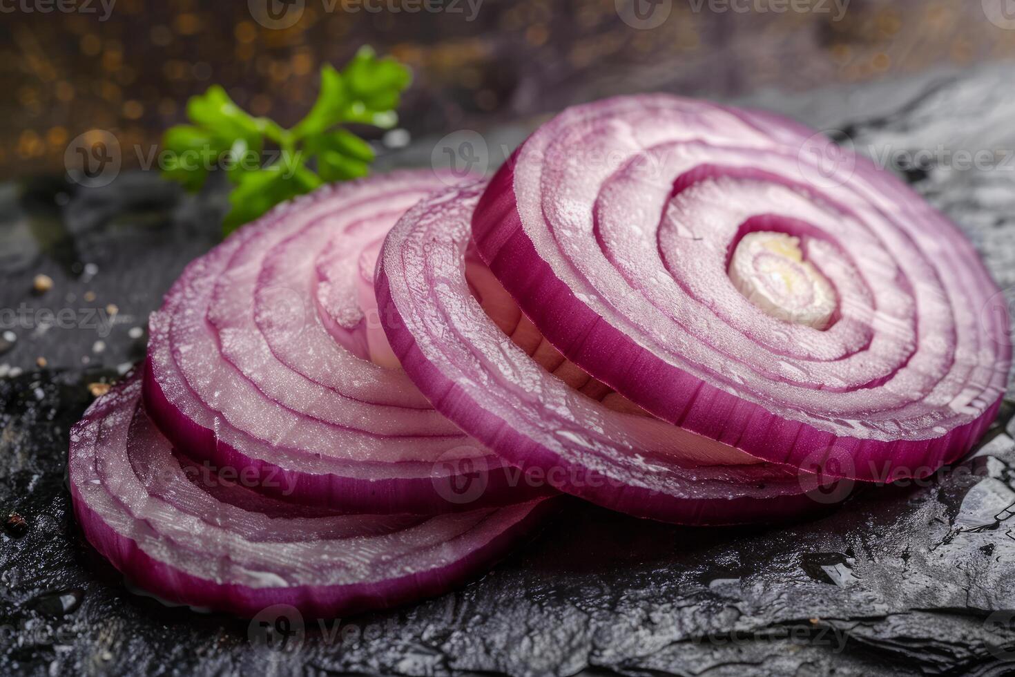 Sliced red onion on slate with parsley and pepper photo
