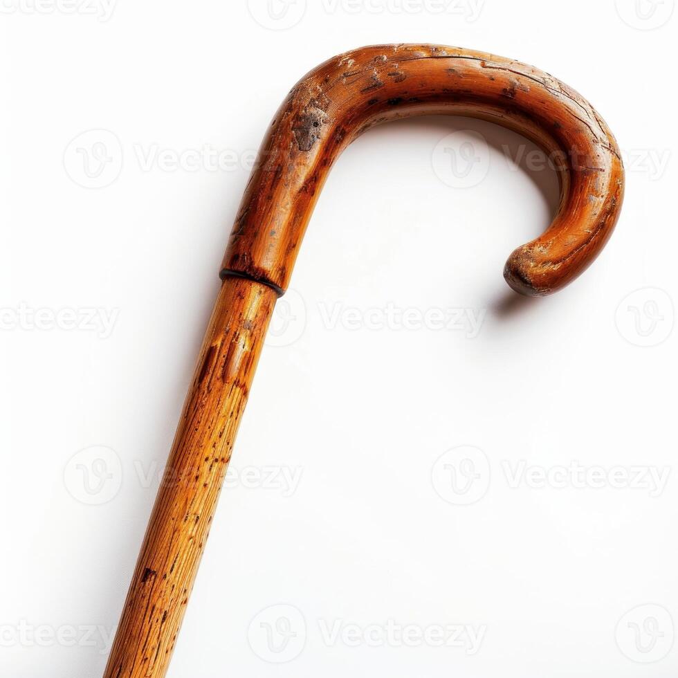 Wooden walking cane resting on white background photo