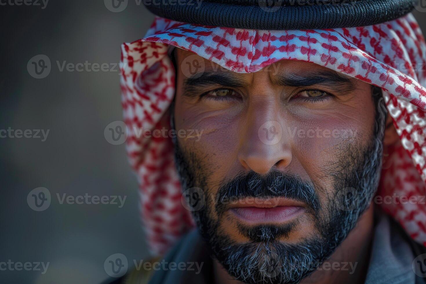 Portrait of bedouin man wearing traditional keffiyeh in desert setting photo