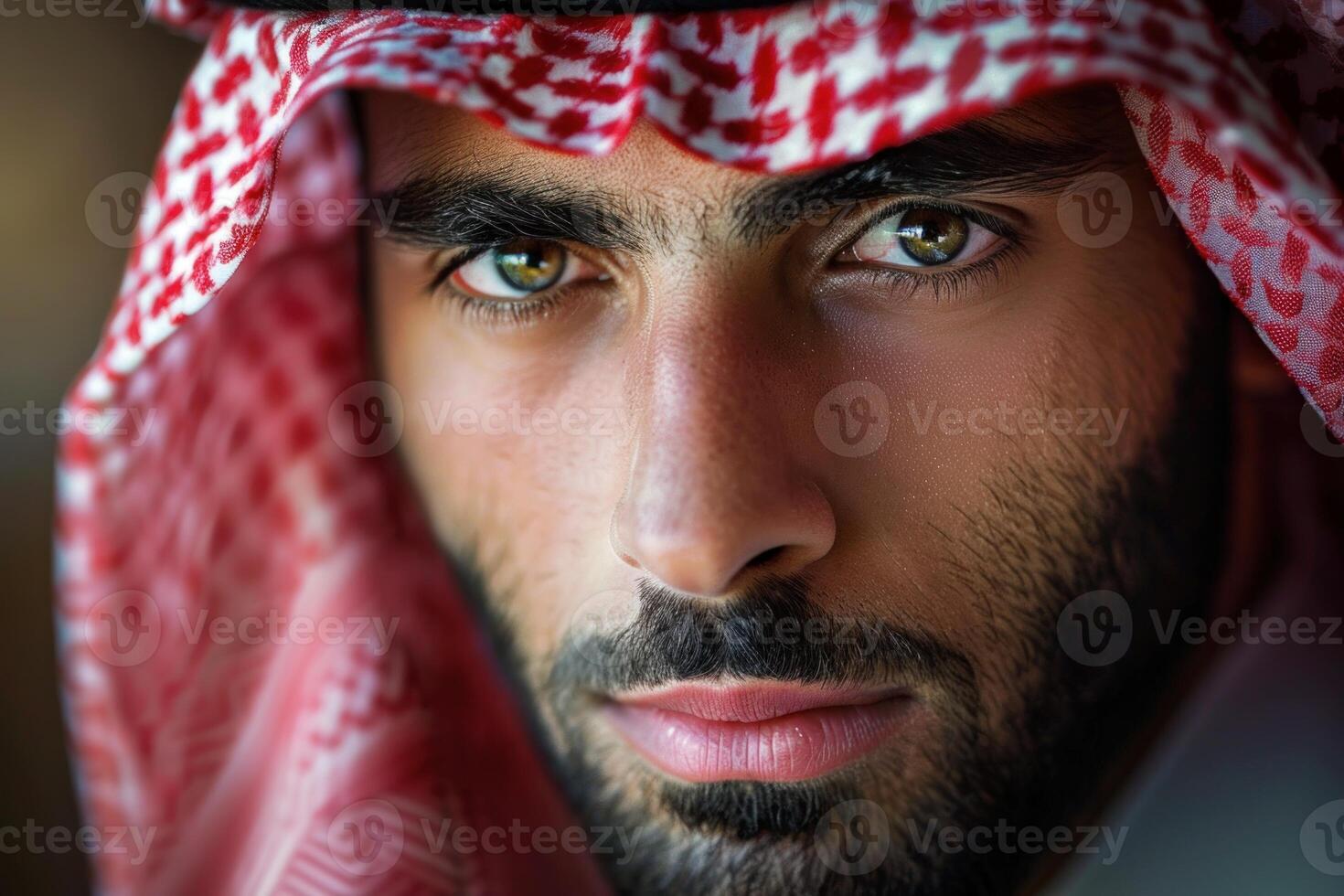 Close up portrait of a serious middle eastern man wearing a red and white keffiyeh photo