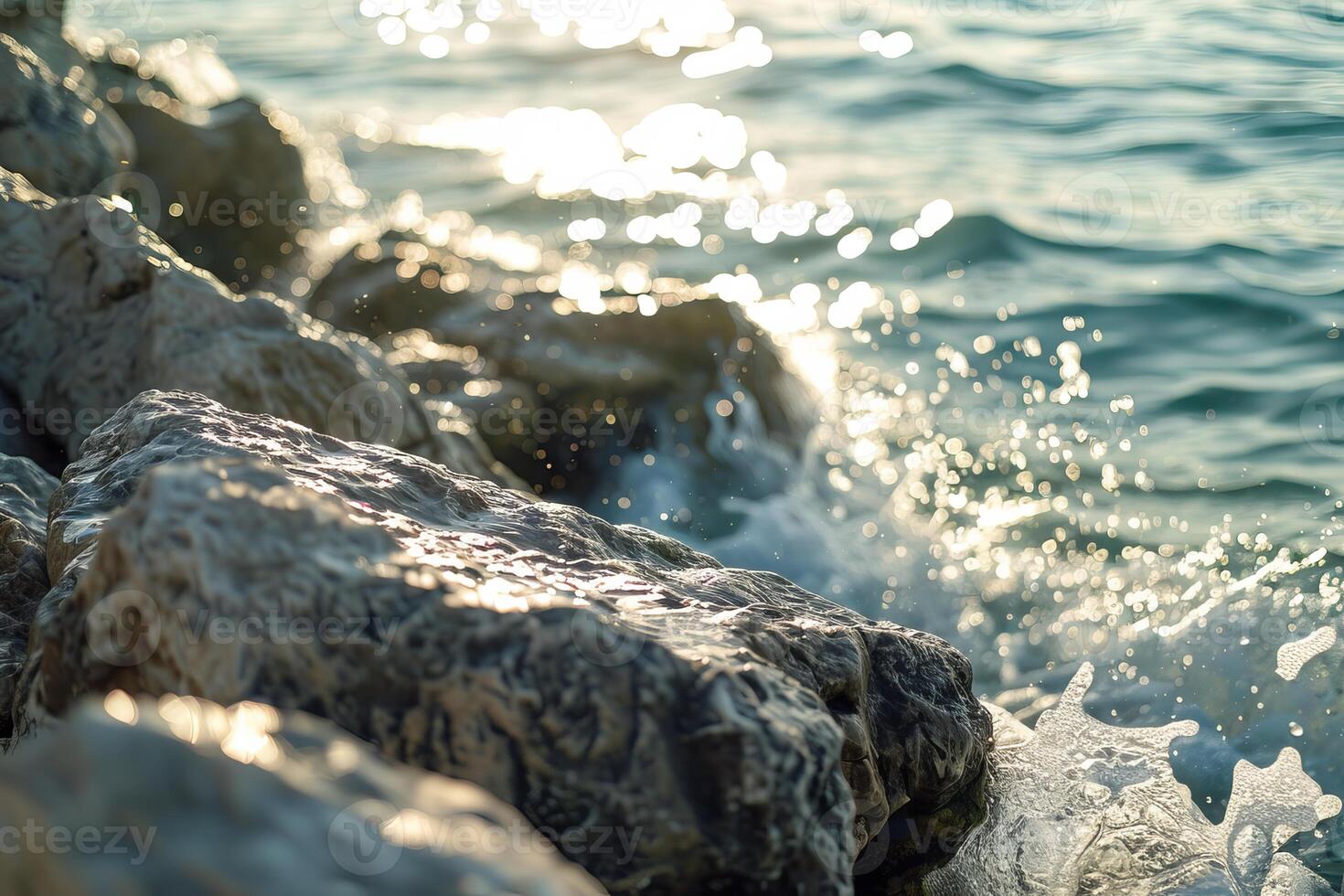 Waves crashing on rocks at sunset, creating sparkling drops photo