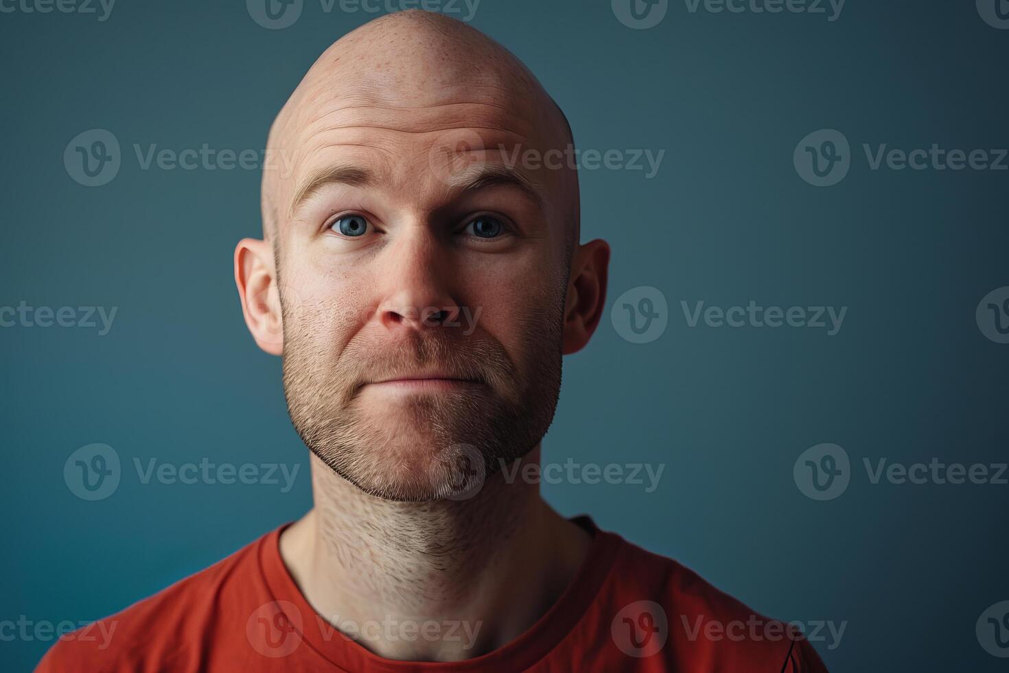 Portrait of bald man with beard showing emotion on blue background photo