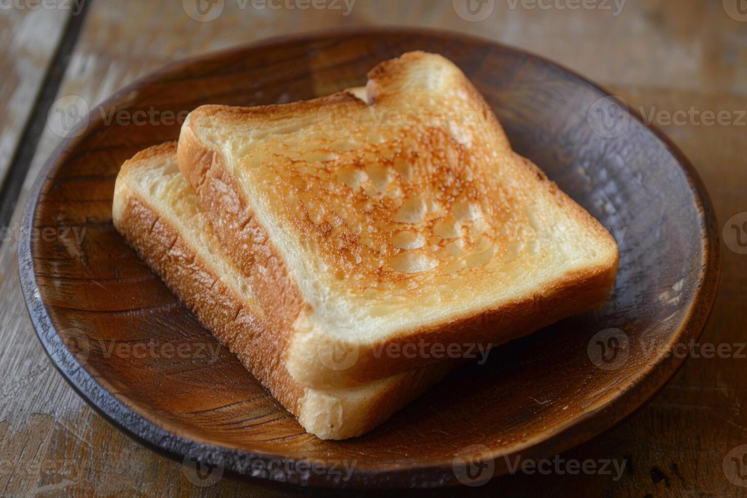 Two slices of toasted bread resting on wooden plate photo