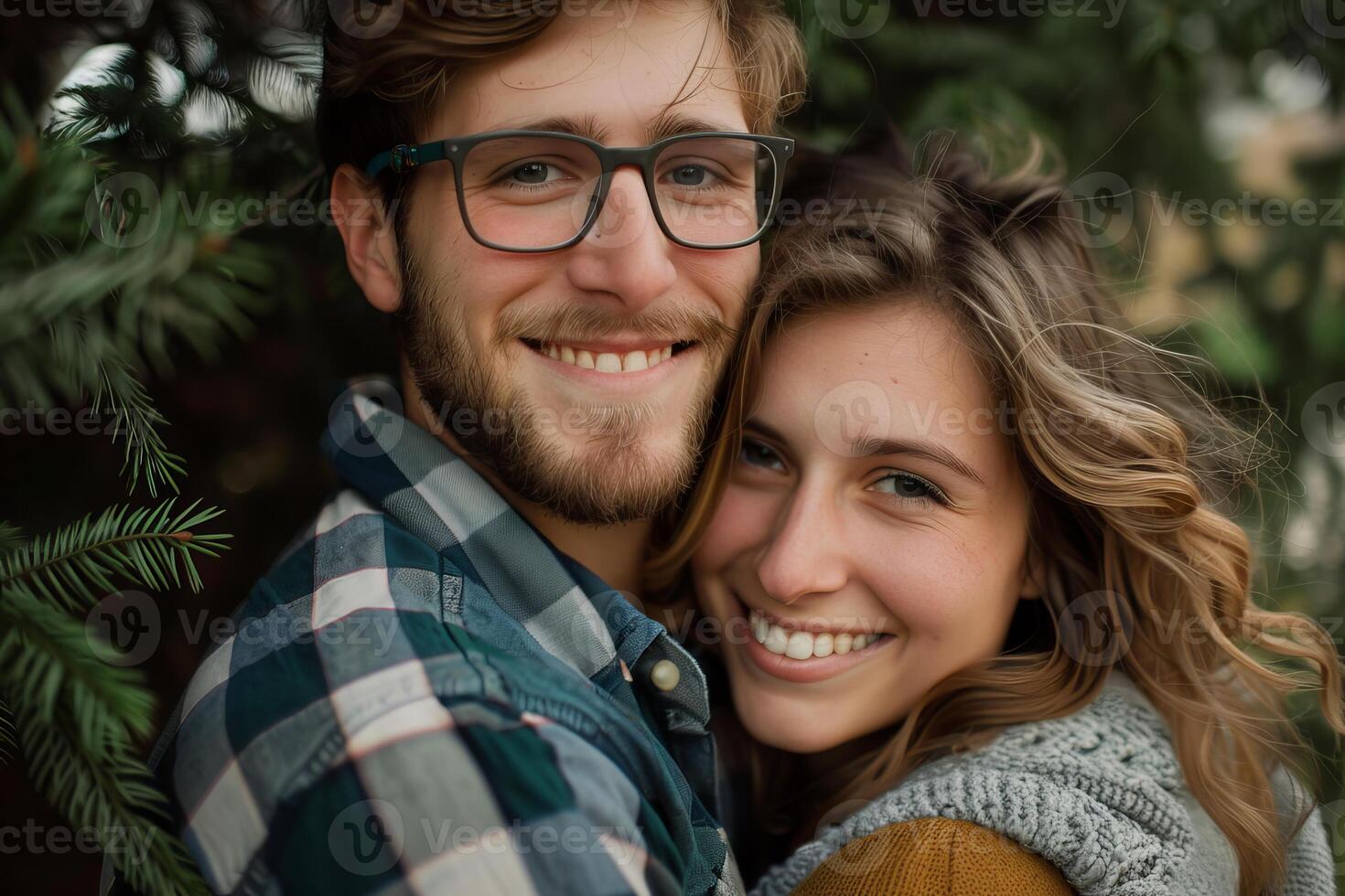 Happy couple smiling and embracing outdoors near pine tree photo
