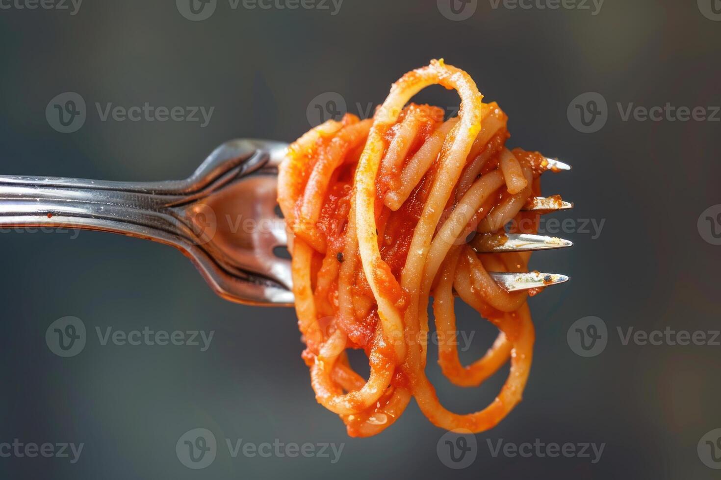 Fork lifting tasty spaghetti with marinara sauce photo