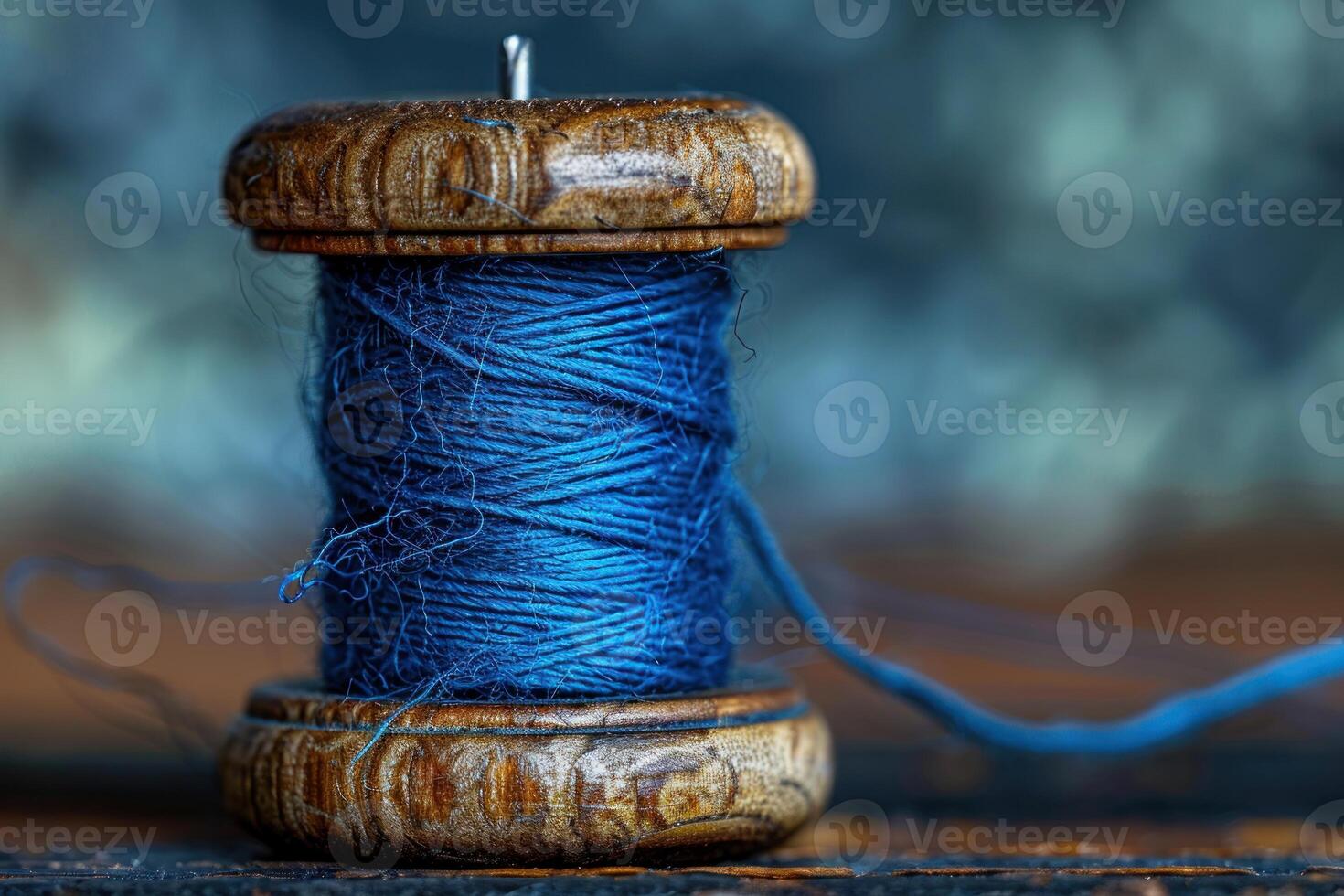 Wooden spool holding blue thread symbolizing traditional craftsmanship photo
