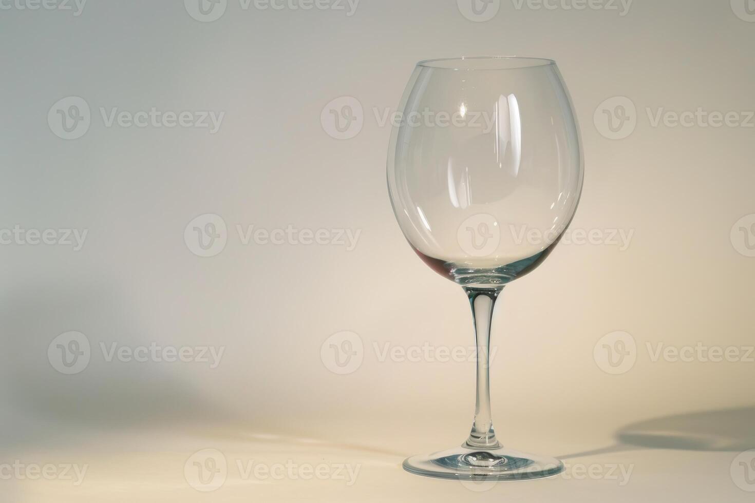 Empty wine glass casting shadow on white background photo