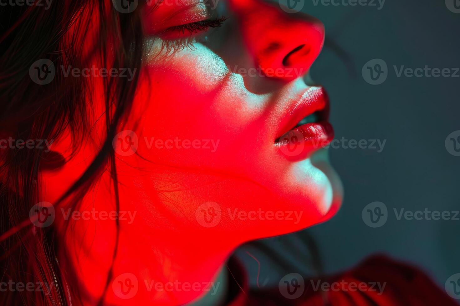 Model posing with red and teal lighting showing perfect makeup photo