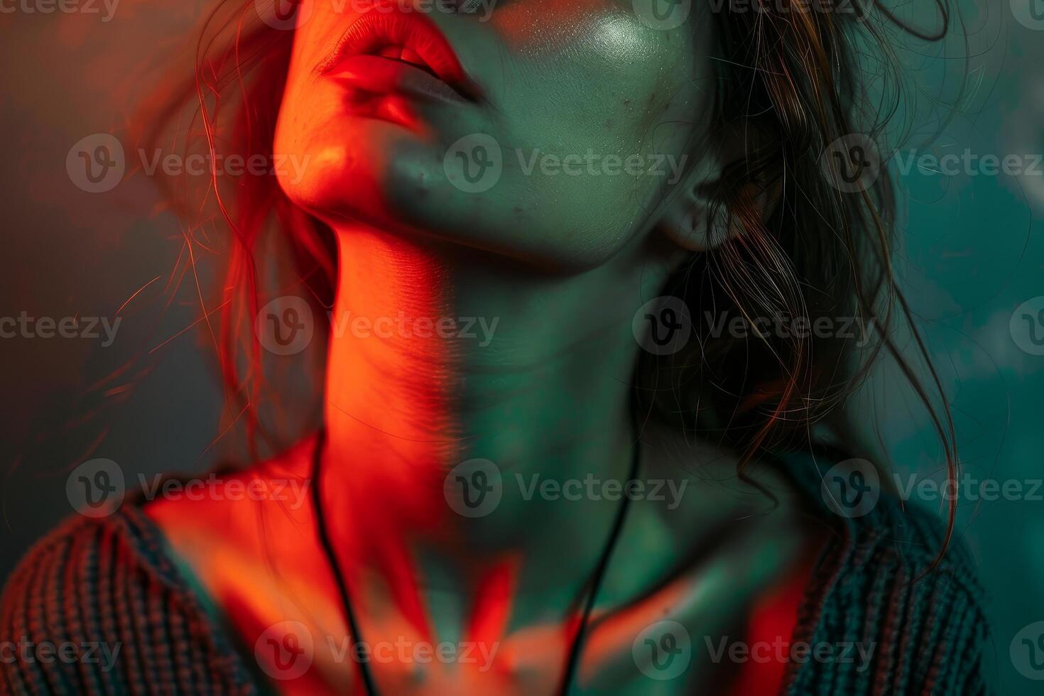 Fashion model posing with red and green lights illuminating neck and face photo