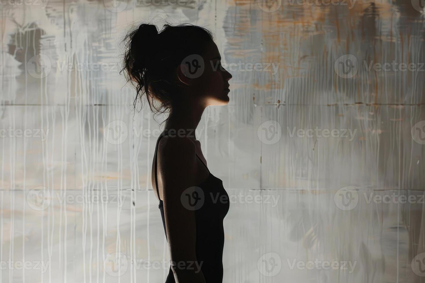 Young woman posing in profile against grunge wall background photo