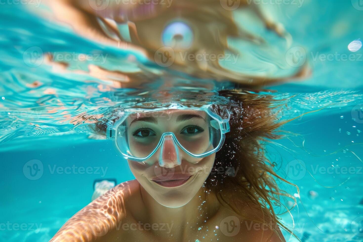 Young woman swimming underwater with snorkeling mask in turquoise water photo