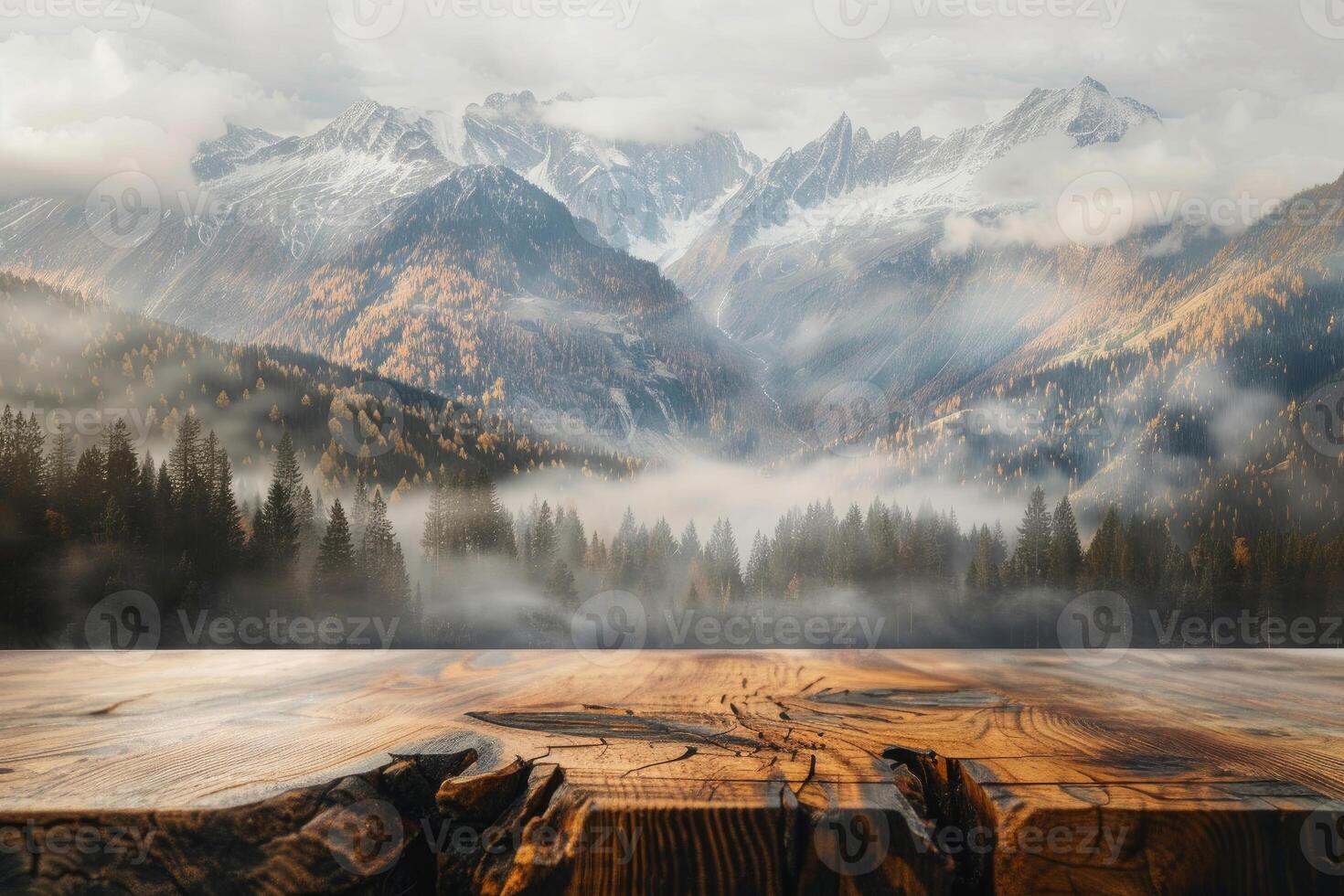 Empty wooden table overlooking a misty mountain landscape with colorful autumn foliage photo