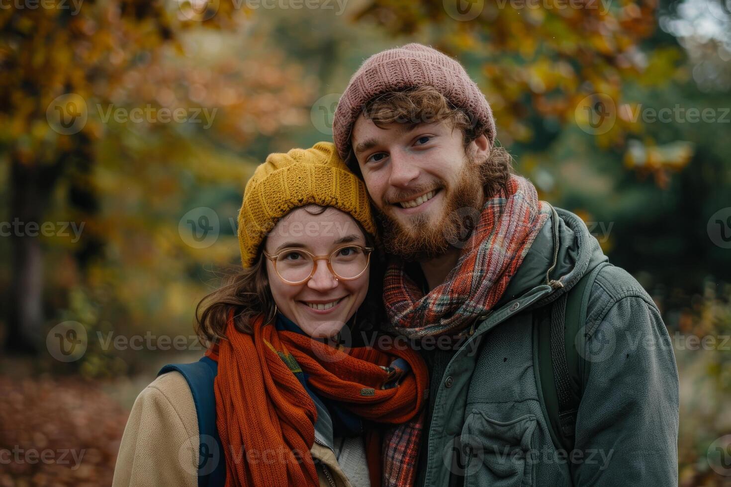 Young couple smiling and wearing warm clothing in fall forest photo