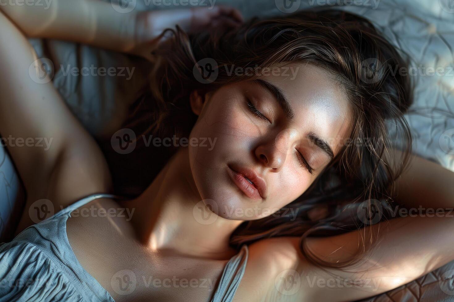 Beautiful young woman sleeping peacefully in bed, enjoying a restful morning photo