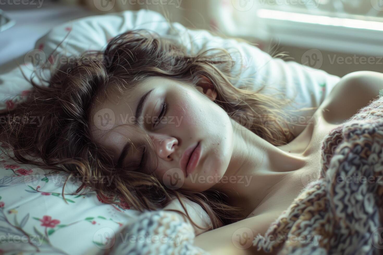 Young woman sleeping peacefully in bed on a sunny morning photo
