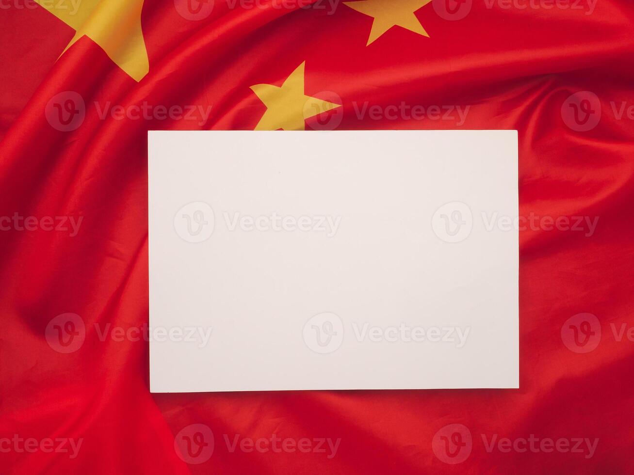 Top view of a blank white paper on the China flag background. photo