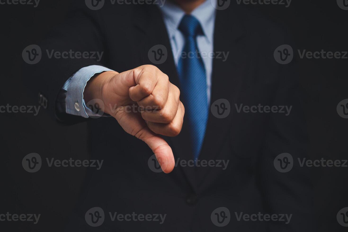 Negative concept. Close-up of businessman's hand showing a thumbs down for dislike service. photo