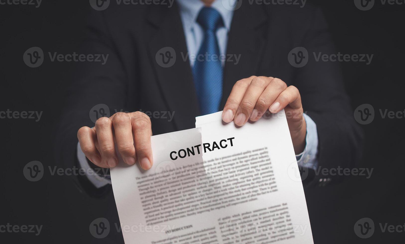 Canceled contract. Businessman is tearing up a contract while standing in the office photo