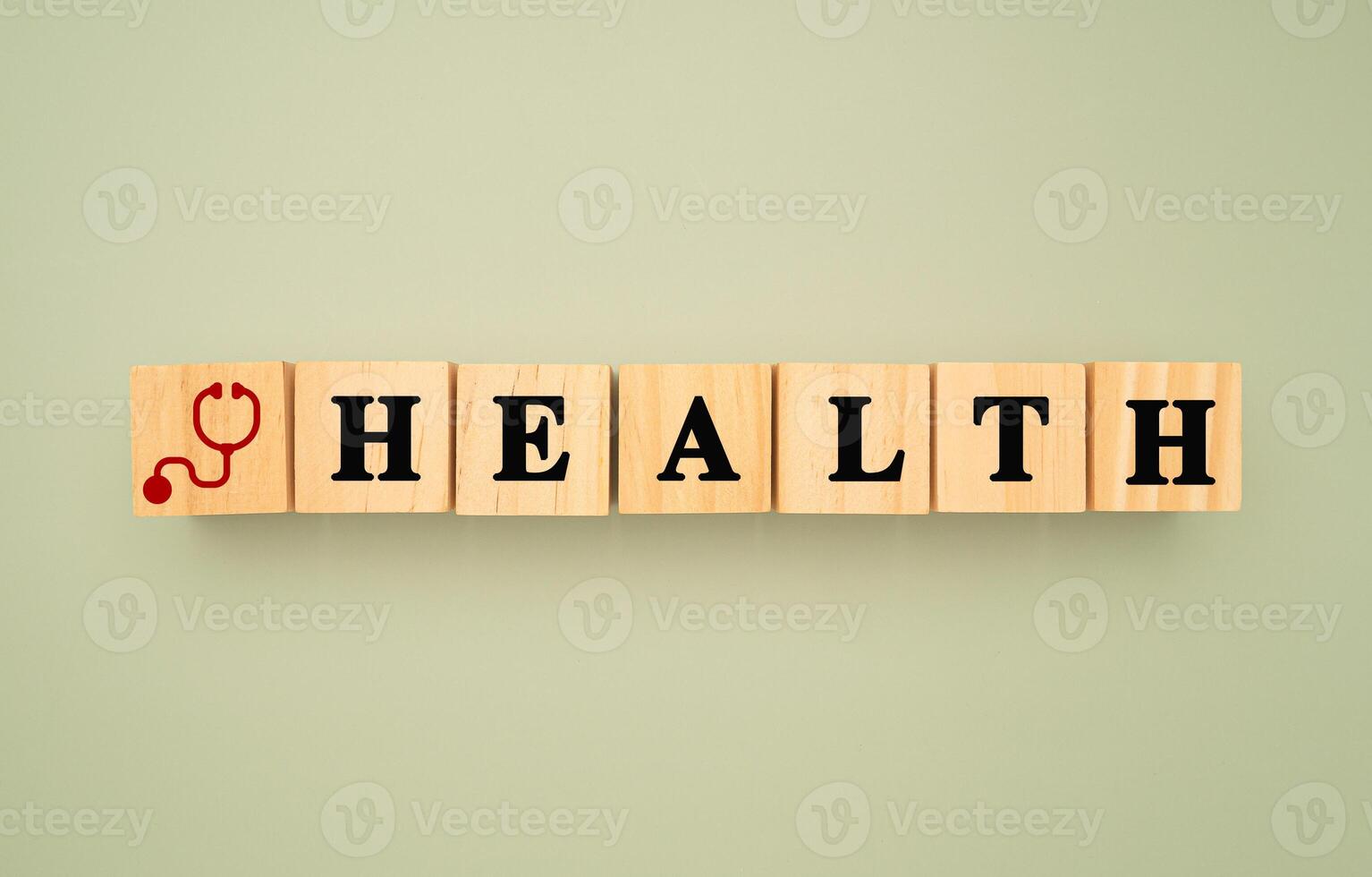 Top view of wooden cubes with words HEALTH and a stethoscope icon on a green background photo