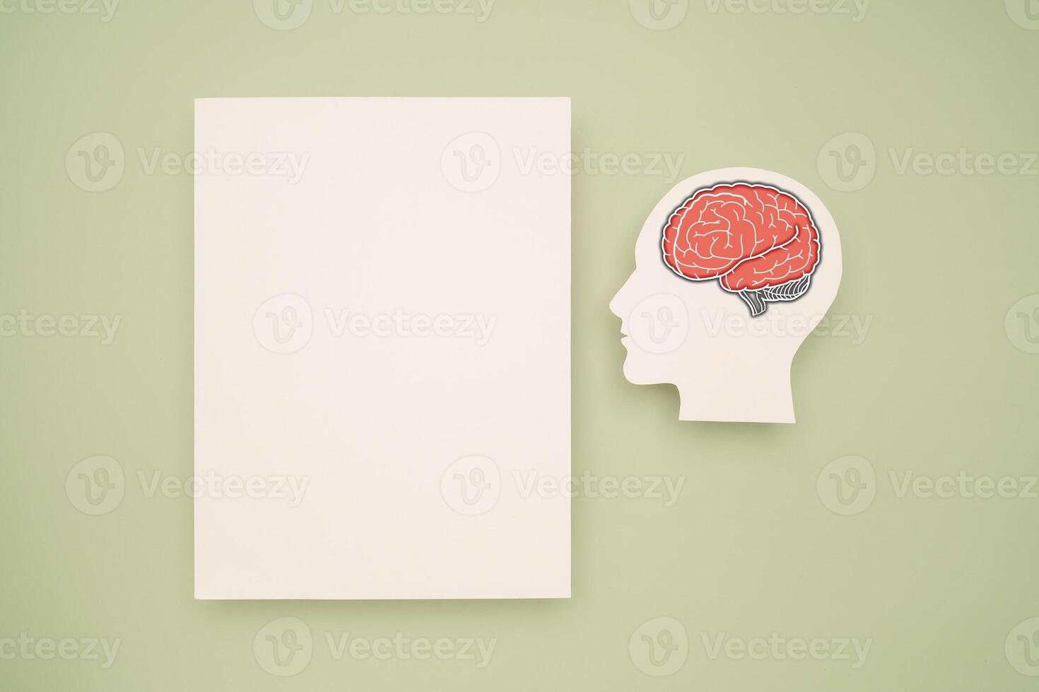 A blank white paper and a red brain shape symbol on a green background. Space for text. photo