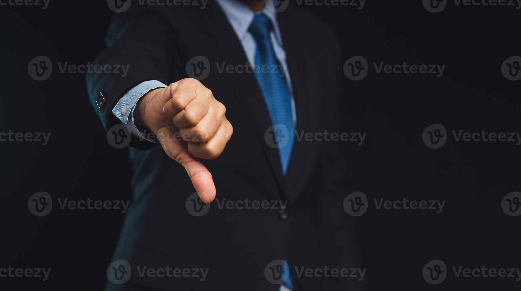 Negative concept. Close-up of businessman's hand showing a thumbs down for dislike service photo