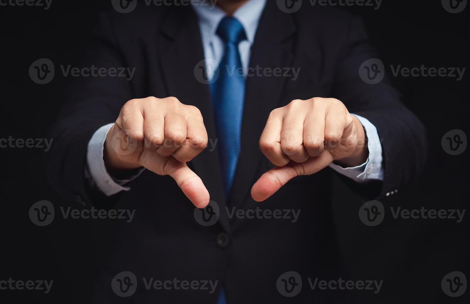 Close-up of businessman's hands showing a thumbs down for dislike service photo
